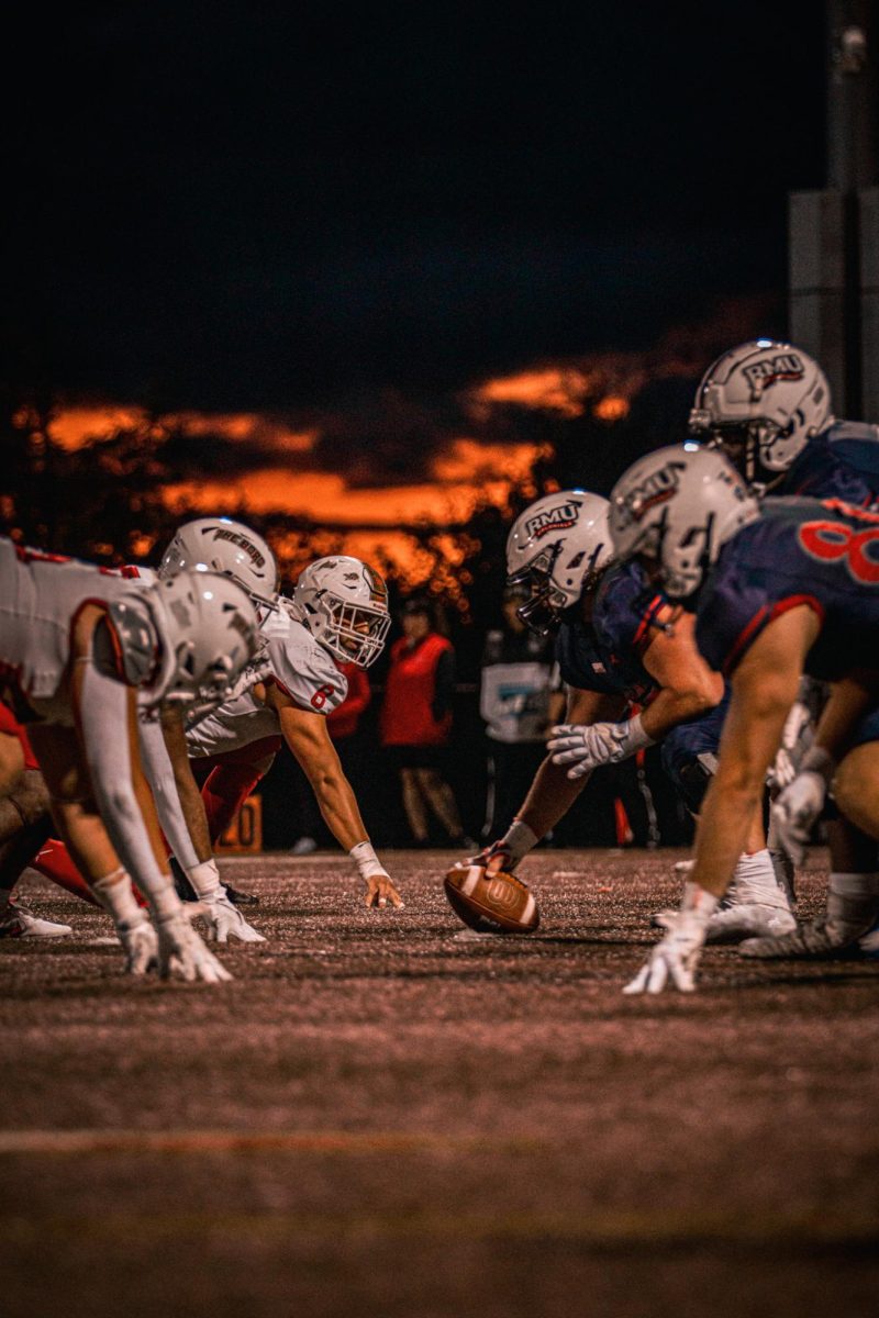 RMU lines up to take the snap in their home opener against Edinboro. -- Photo Credits: Connor Gerst